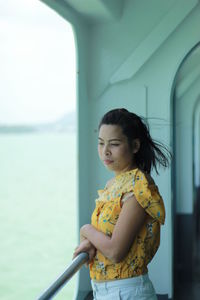 Woman looking away while standing in boat