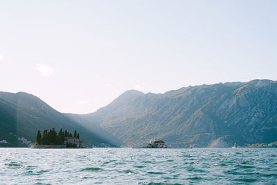 Scenic view of sea and mountains against sky