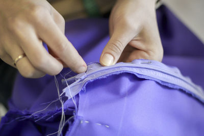 Women's hands sew a skirt. sew on the zipper. handmade work.