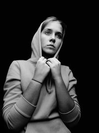 Portrait of a beautiful young woman over black background