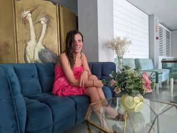 Portrait of woman sitting on sofa at home