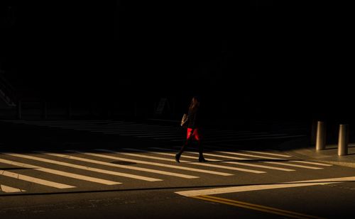 Woman crossing road in city