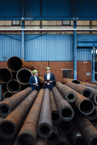 Male professionals working in pipe warehouse