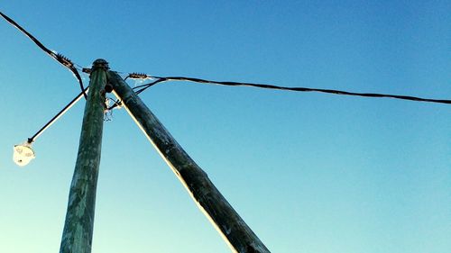 Low angle view of barbed wire against blue sky