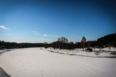 Scenic view of snowcapped landscape against clear blue sky