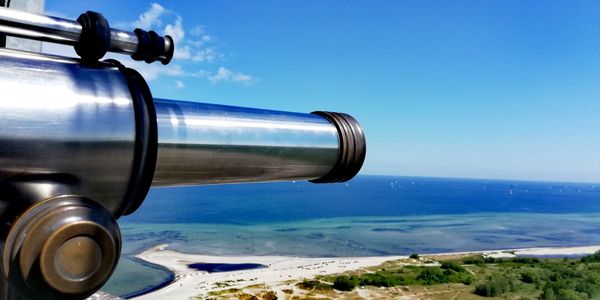 Close-up of coin-operated binoculars against sea