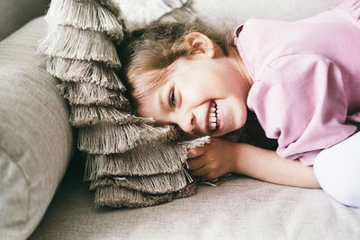 A three year old child poses for the camera at home.