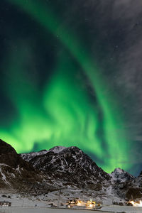 Scenic view of snowcapped mountains against sky at night