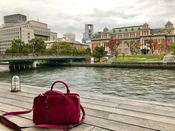 Red boat in river against buildings in city