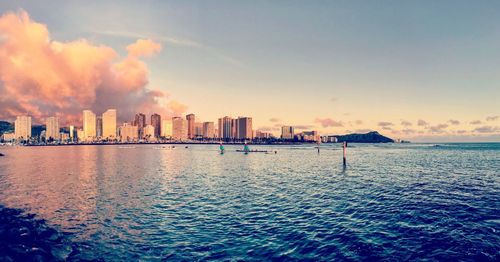 View of city at waterfront during sunset