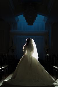 Bride wearing dress while standing in darkroom