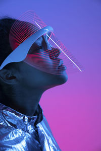 Woman in futuristic smart glasses against multi-colored background