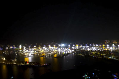 Illuminated cityscape against sky at night