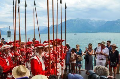 Group of people against boats in sea