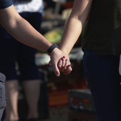 Midsection of couple holding hands