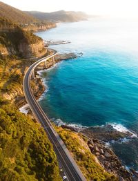 Aerial view of road by sea during sunset