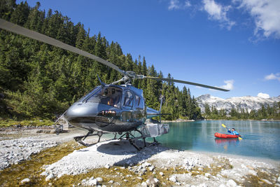 Active man paddling next to helicopter during an adventure tour.