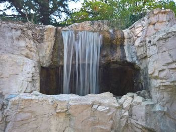 Scenic view of waterfall against trees