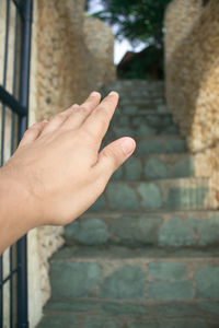 Cropped image of person hand on wall