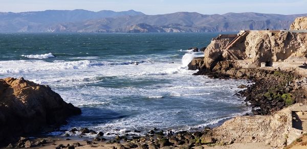 Scenic view of sea and mountains against sky