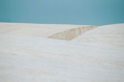 Close-up of concrete wall against clear blue sky