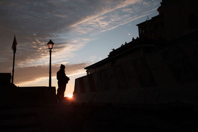 Silhouette of a woman watching the sunset in genova.