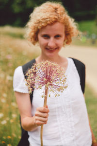 Portrait of a smiling woman holding plant