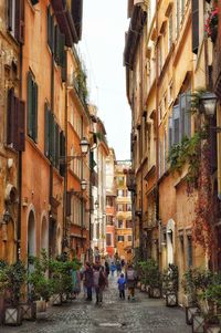 People walking on street amidst buildings in city