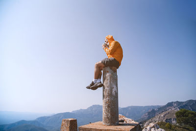 Low angle view of person against mountain against blue sky