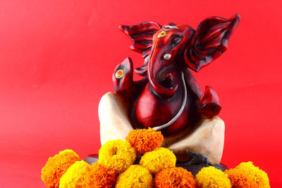 Close-up of buddha statue against red background