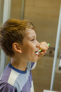 Close-up of boy brushing teeth at bathroom