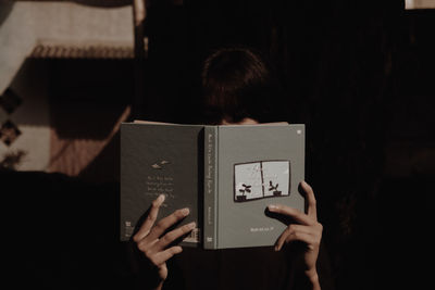 Rear view of girl reading book
