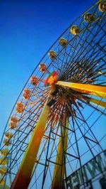 Low angle view of ferris wheel against blue sky