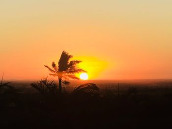 Silhouette tree by sea against romantic sky at sunset