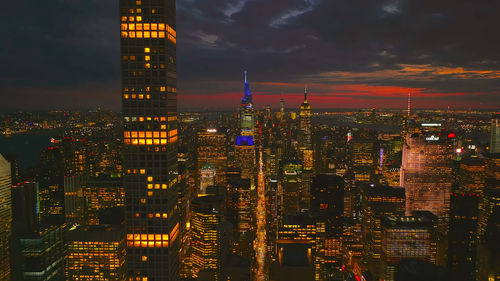 Illuminated cityscape against sky at night