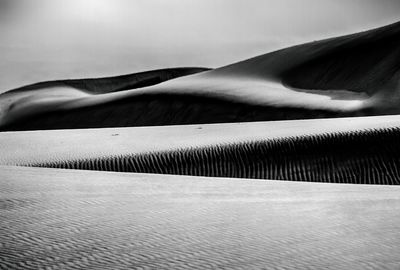 Sand dune in desert against sky