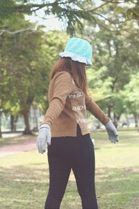 Woman in warm clothing walking on field