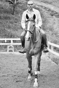 Portrait of mid adult man riding horse in pen