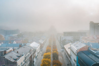 Aerial view of buildings amidst fog in city