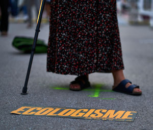 Low section of person standing on road in city