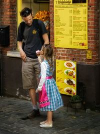 Full length of girl standing against wall