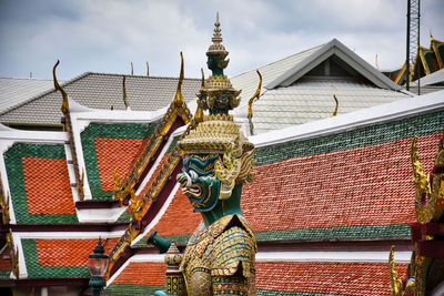 Statues on roof of building against sky