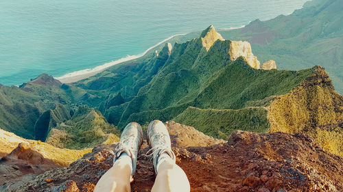 Low section of man on mountains against sea