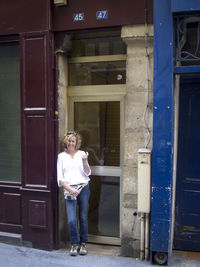 Full length of woman standing at entrance of building