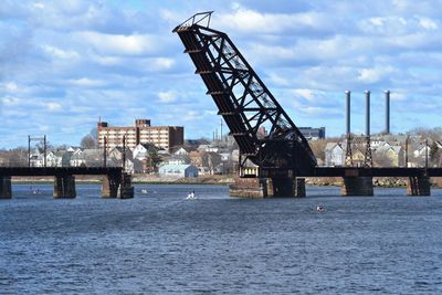 Cranes at pier against sky