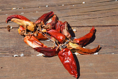 High angle view of dried red chili peppers on wooden table