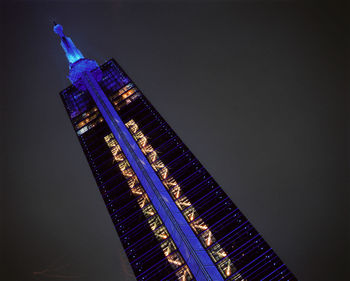 Low angle view of illuminated buildings against sky at night