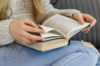 Midsection of woman reading book