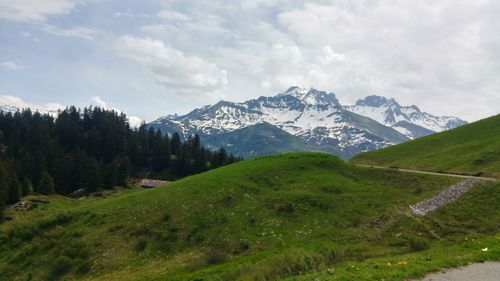 Scenic view of field and mountains against sky