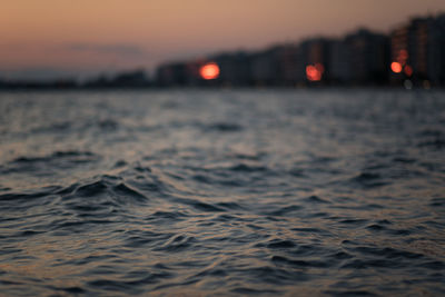 Surface level of sea against sky during sunset